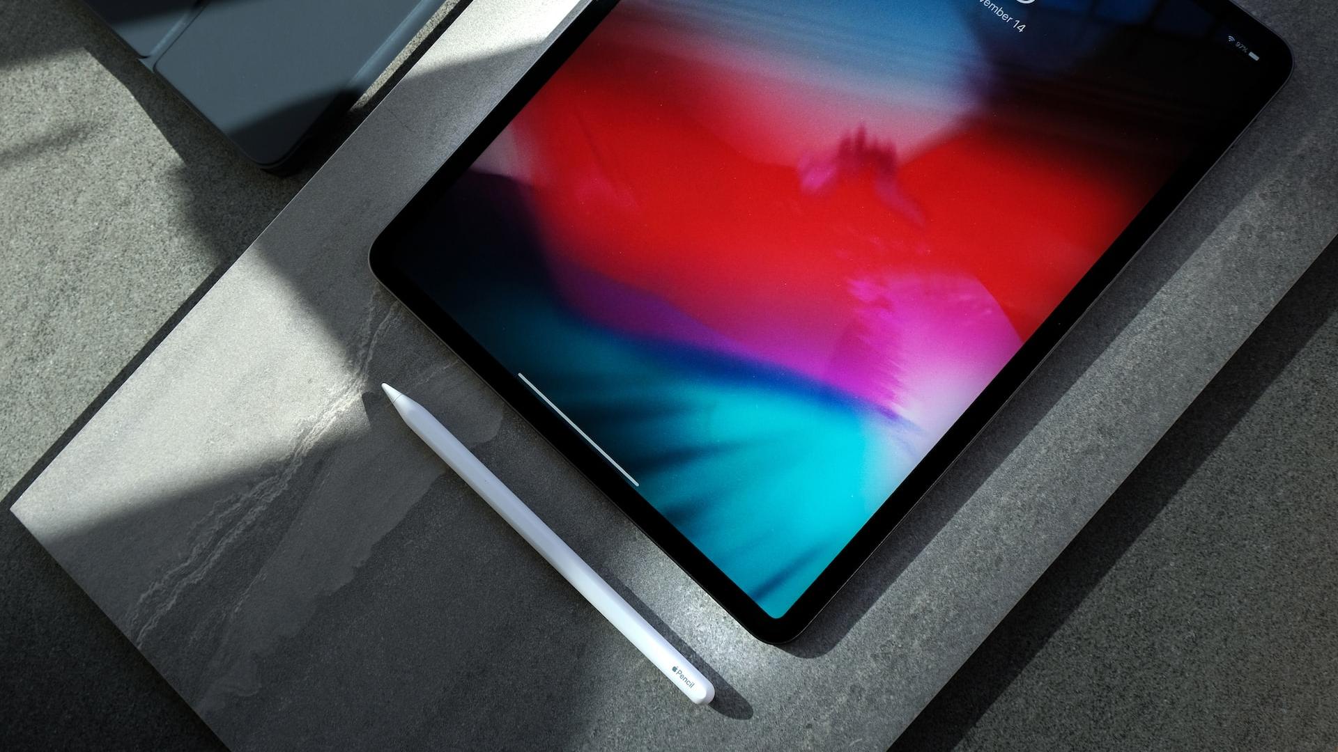 black iPad with white stylus pen
